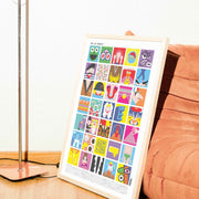 Affiche illustrée “Vive la France !” encadrée, posée au sol contre un fauteuil en velours terracotta, composée d’une mosaïque colorée d’illustrations pop inspirées de symboles et scènes emblématiques de la culture française.
