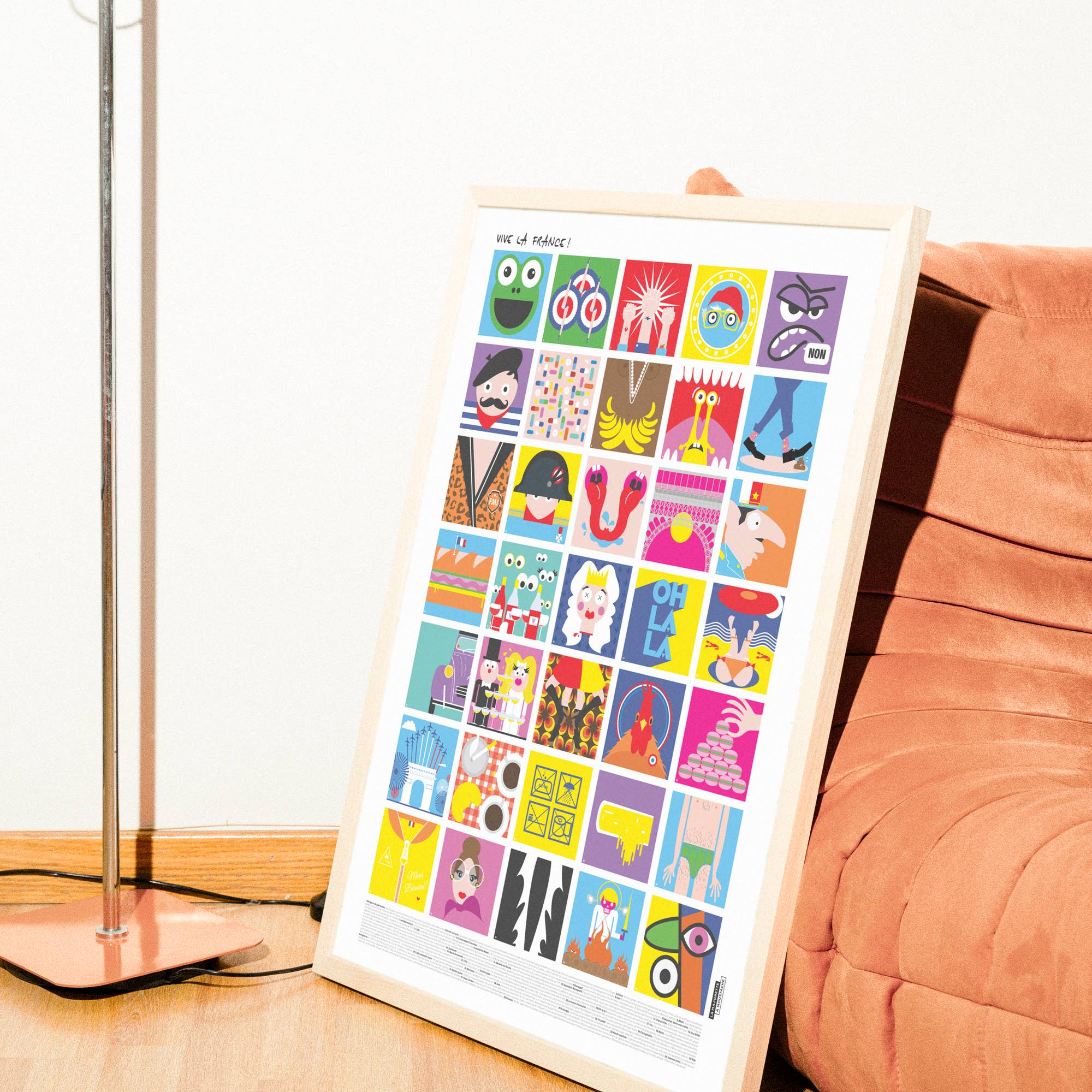 Affiche illustrée “Vive la France !” encadrée, posée au sol contre un fauteuil en velours terracotta, composée d’une mosaïque colorée d’illustrations pop inspirées de symboles et scènes emblématiques de la culture française.