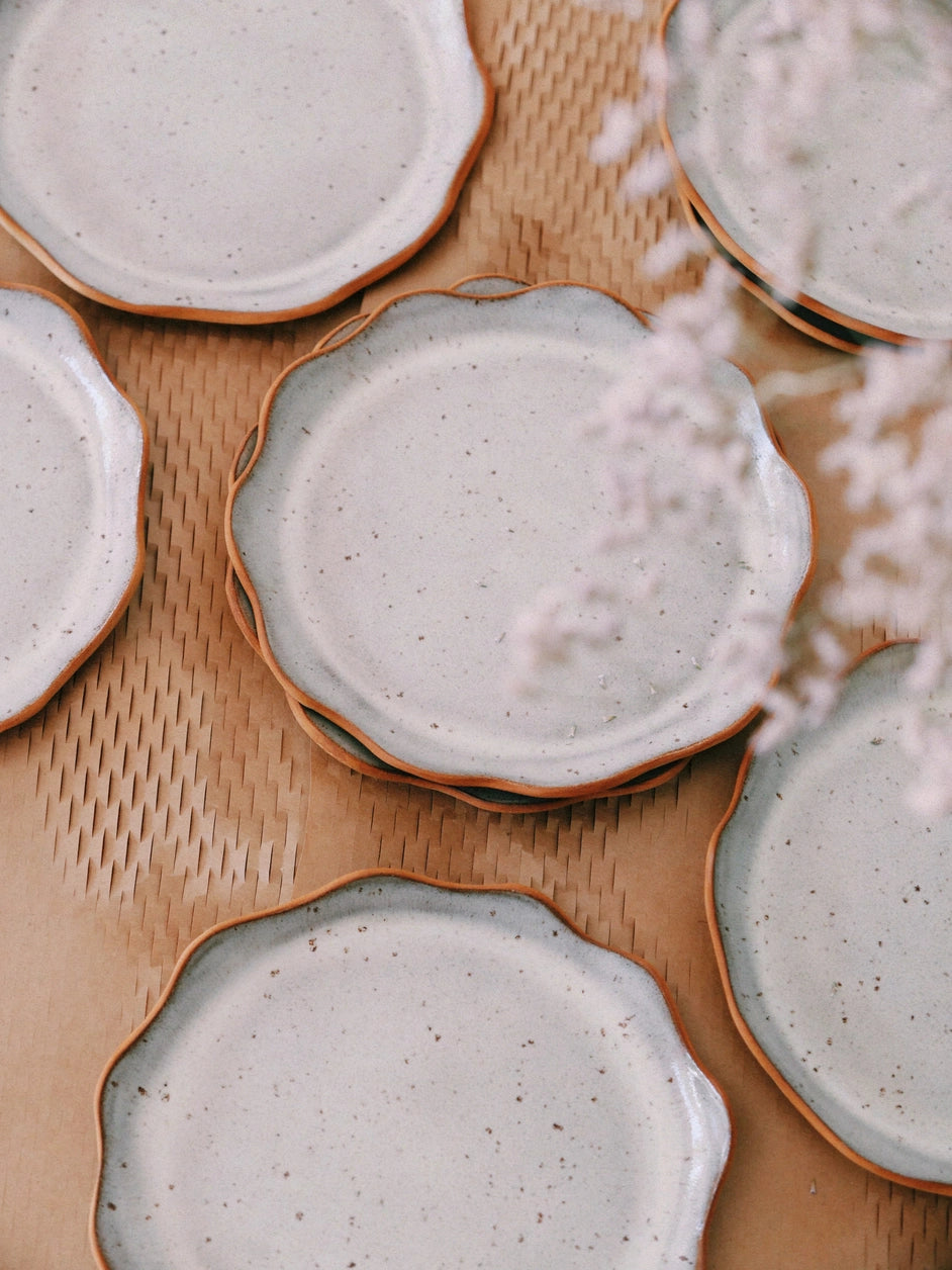 Des assiettes en grès avec des bords ondulés de couleur gris clair.