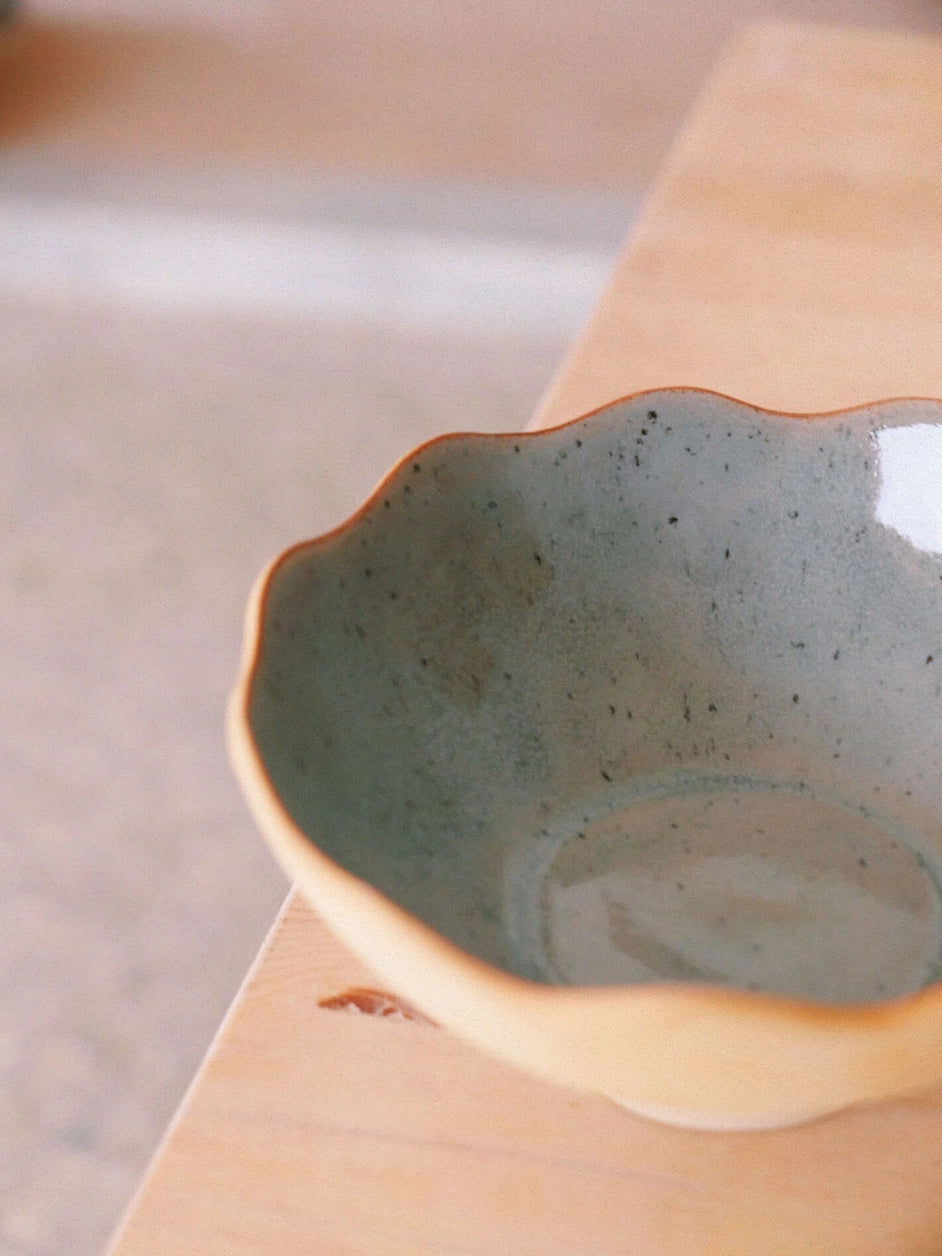 Un bol en grès de couleur gris clair posé sur une table.