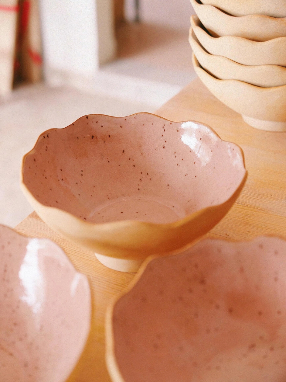 Des bols en grès de couleur bois de rose posés sur une table.
