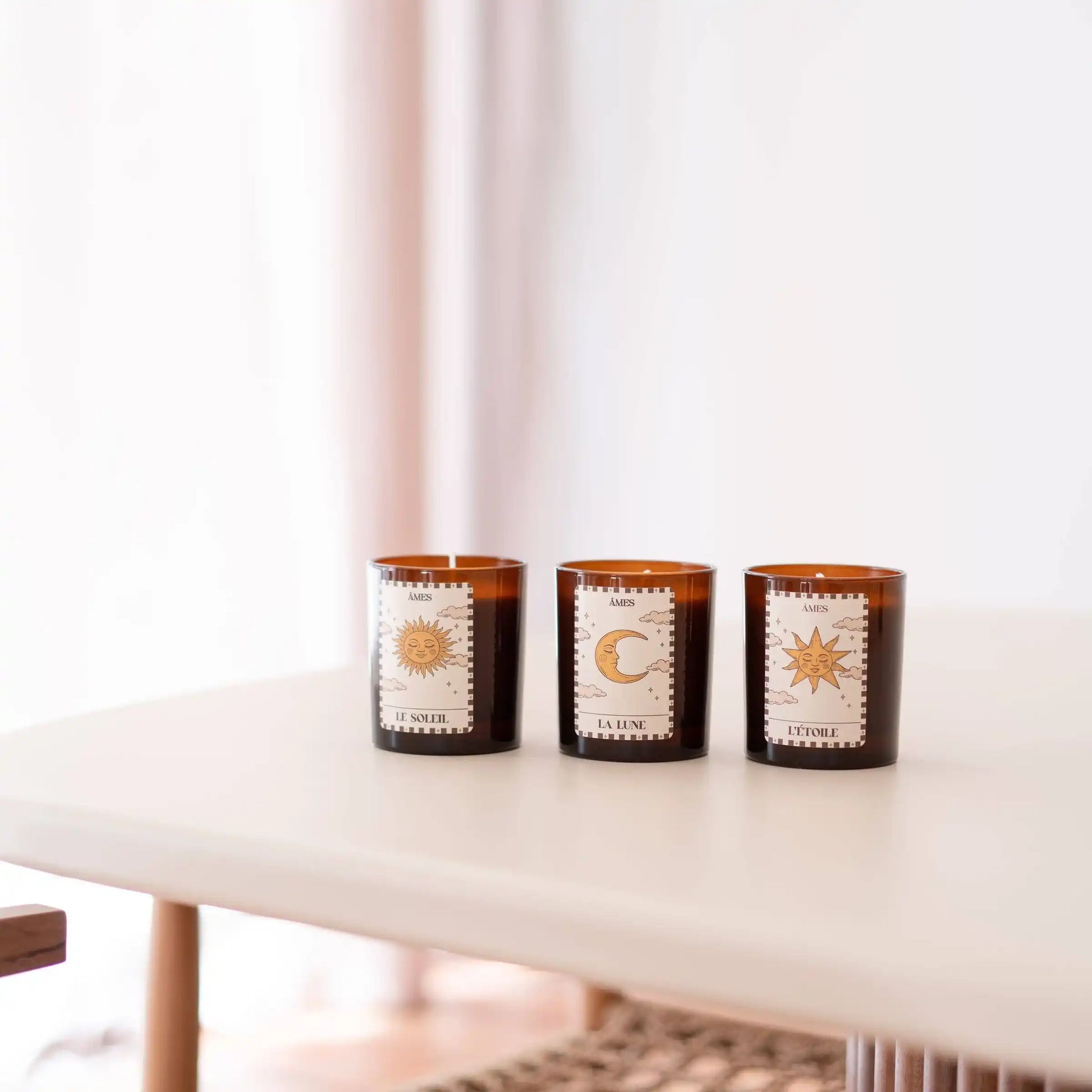 Les trois bougies parfumées de la collection Tarot AMES — Le Soleil, La Lune et L’Étoile — réunies sur une table dans une ambiance épurée et lumineuse.