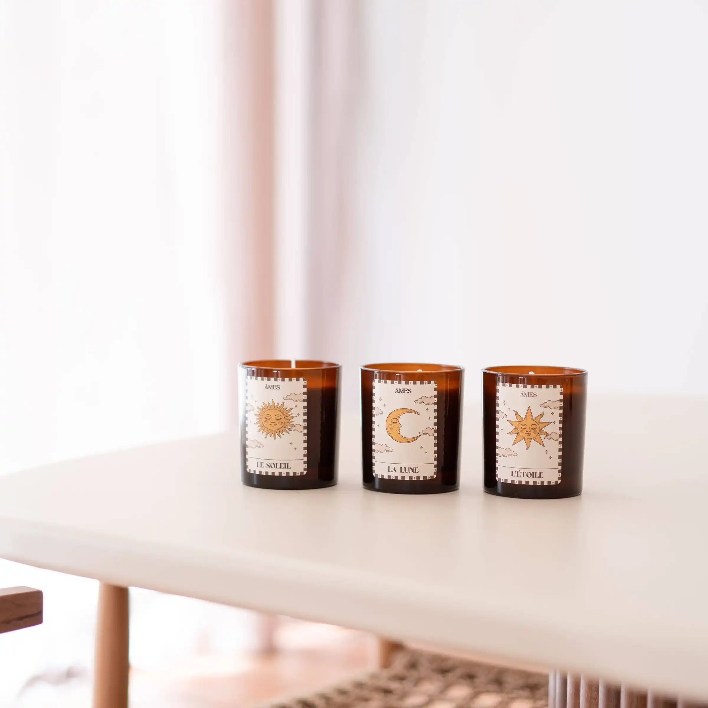 Les trois bougies parfumées de la collection Tarot AMES — Le Soleil, La Lune et L’Étoile — réunies sur une table dans une ambiance épurée et lumineuse.