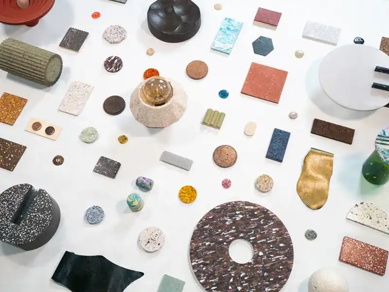 Objets et échantillons de matériaux design disposés sur table, recherche et création en design d’objets contemporains.