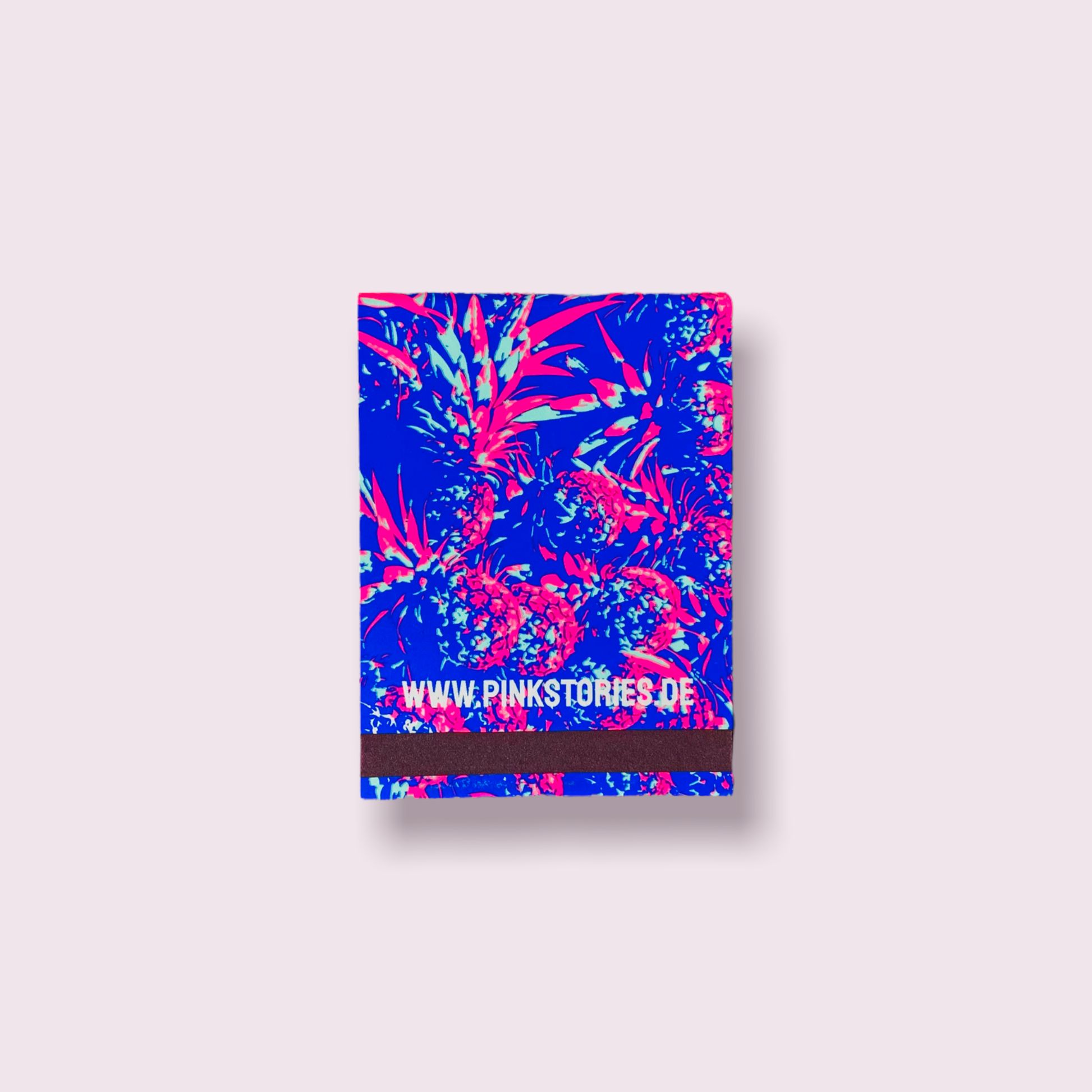 Carnet d’allumettes au design tropical bleu électrique et rose néon, orné d’un motif d’ananas stylisé avec logo en façade.