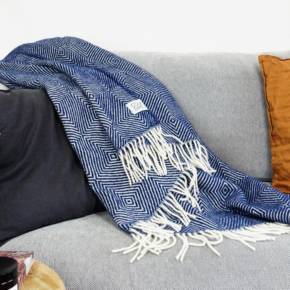 Plaid bleu sur un canapé gris.