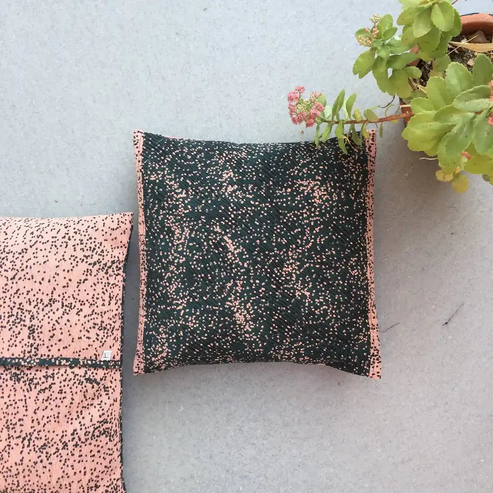 Coussin décoratif réversible en tissu jacquard vert et rose à motif graphique, design textile contemporain.