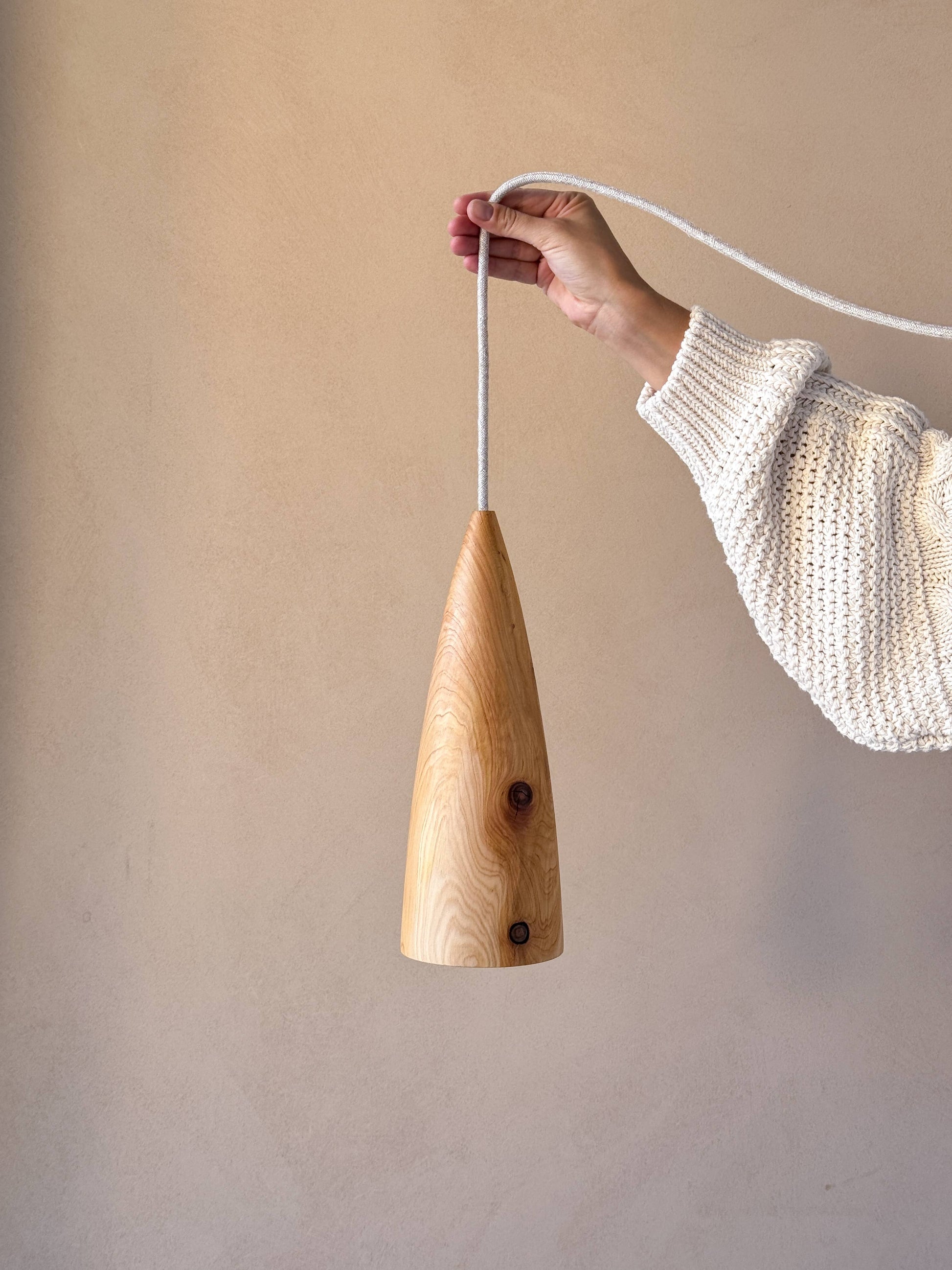 Une lampe en bois, tenue par une femme.