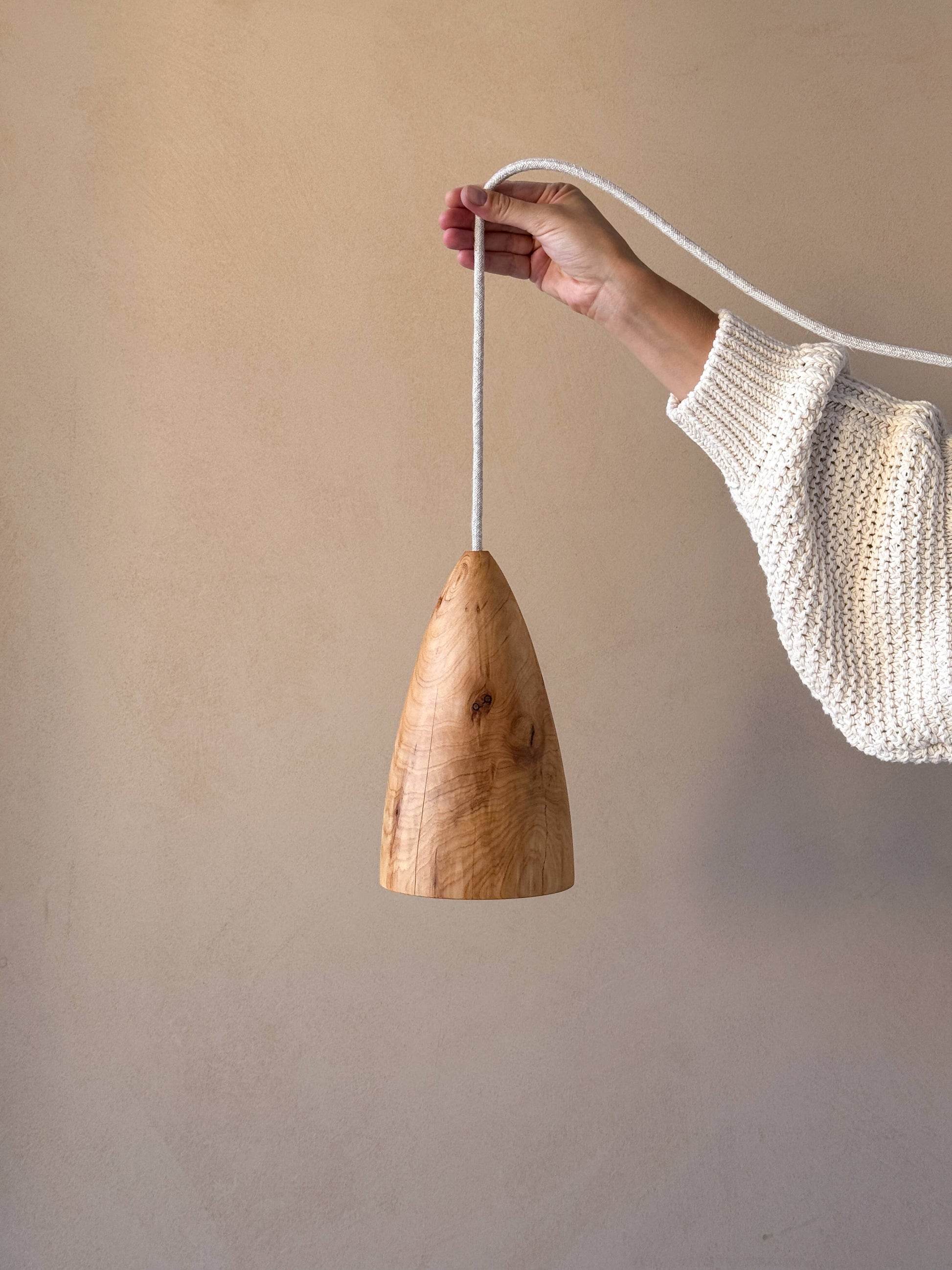 Une lampe en bois, tenue par une femme.