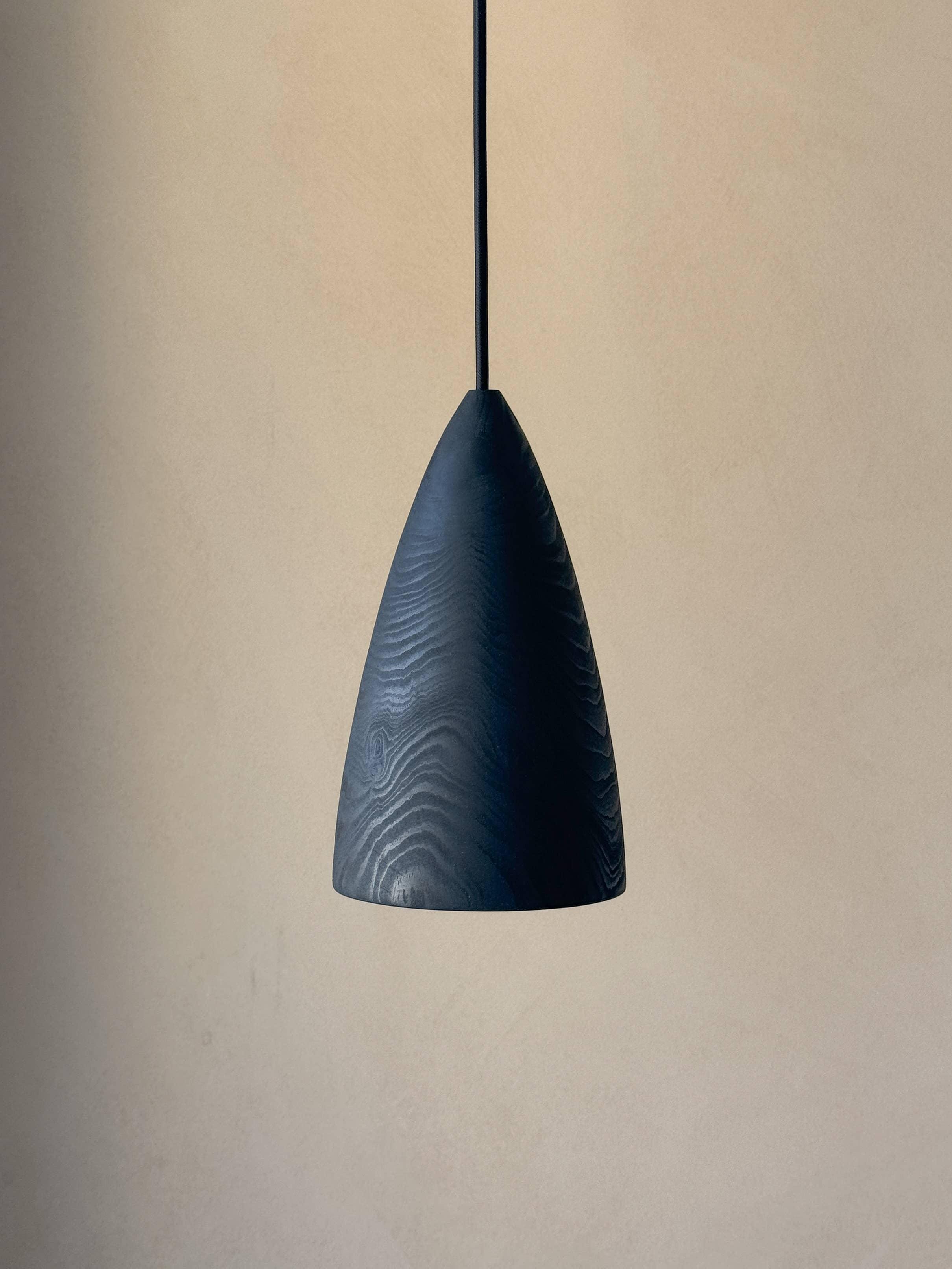 Une lampe en bois noire suspendue.