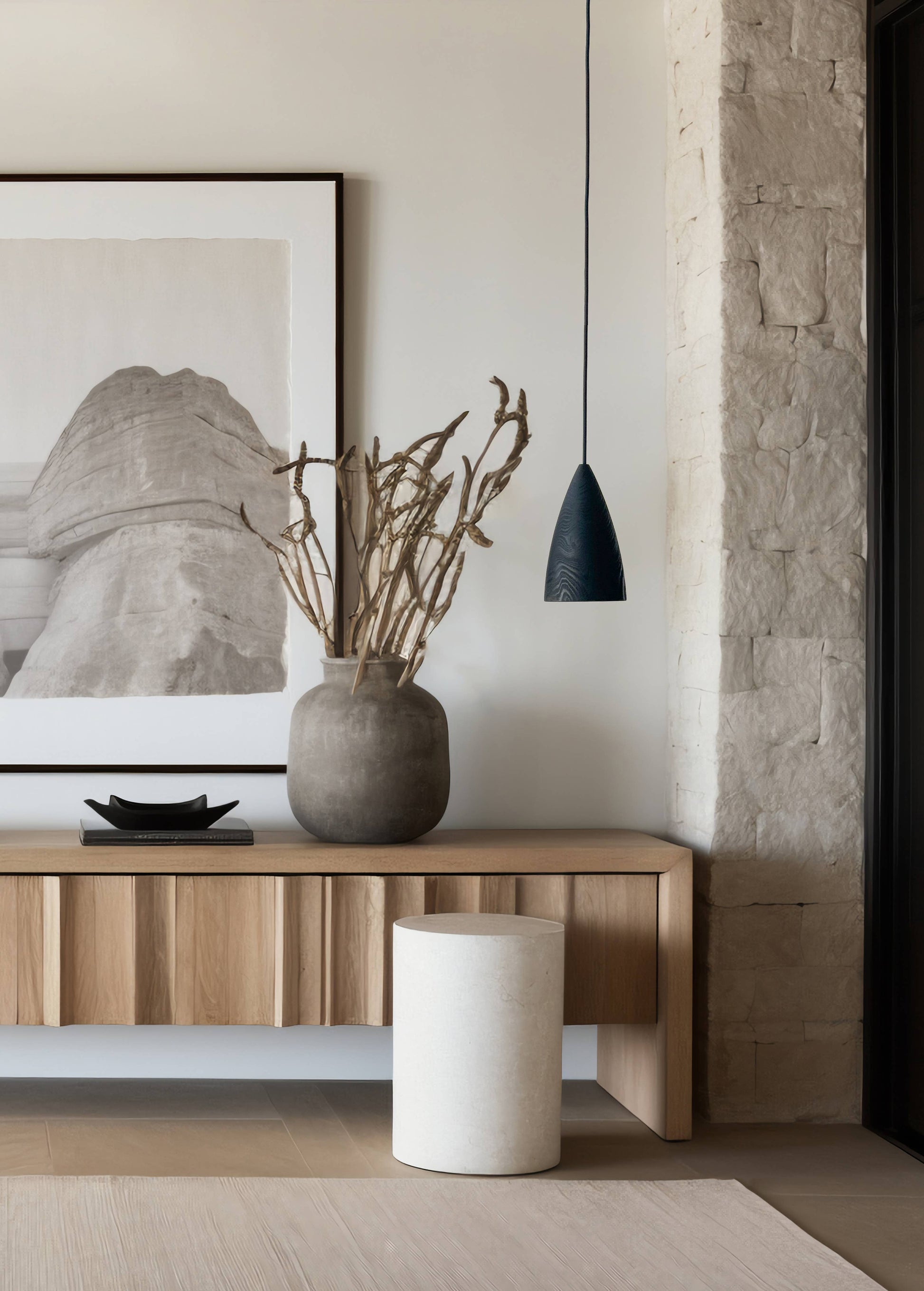 Une pièce avec une console en bois sur laquelle est posée un vase. Un tableau est accroché au mur et une lampe est suspendue au dessus de la console.