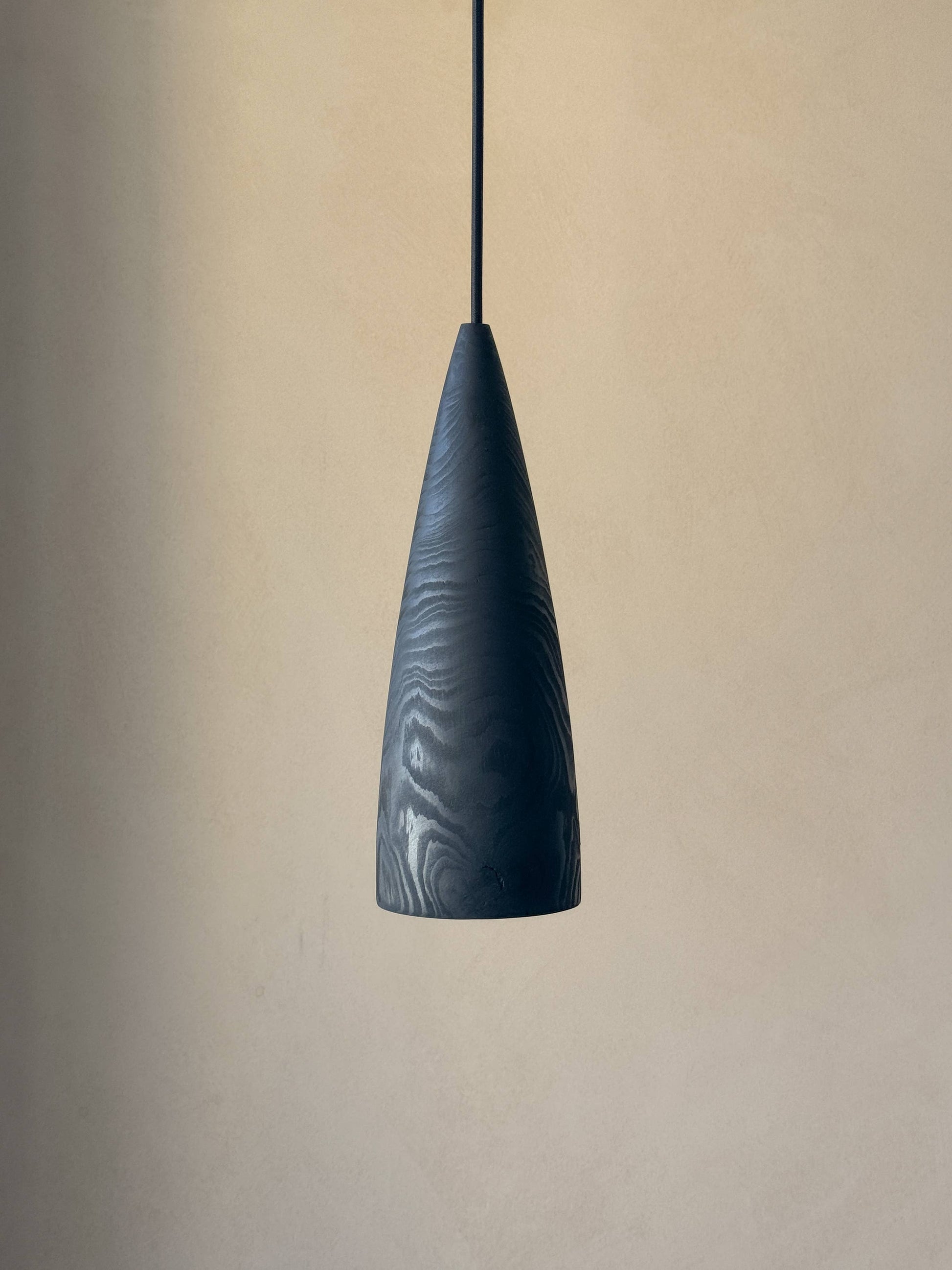Une lampe en bois noire suspendue.