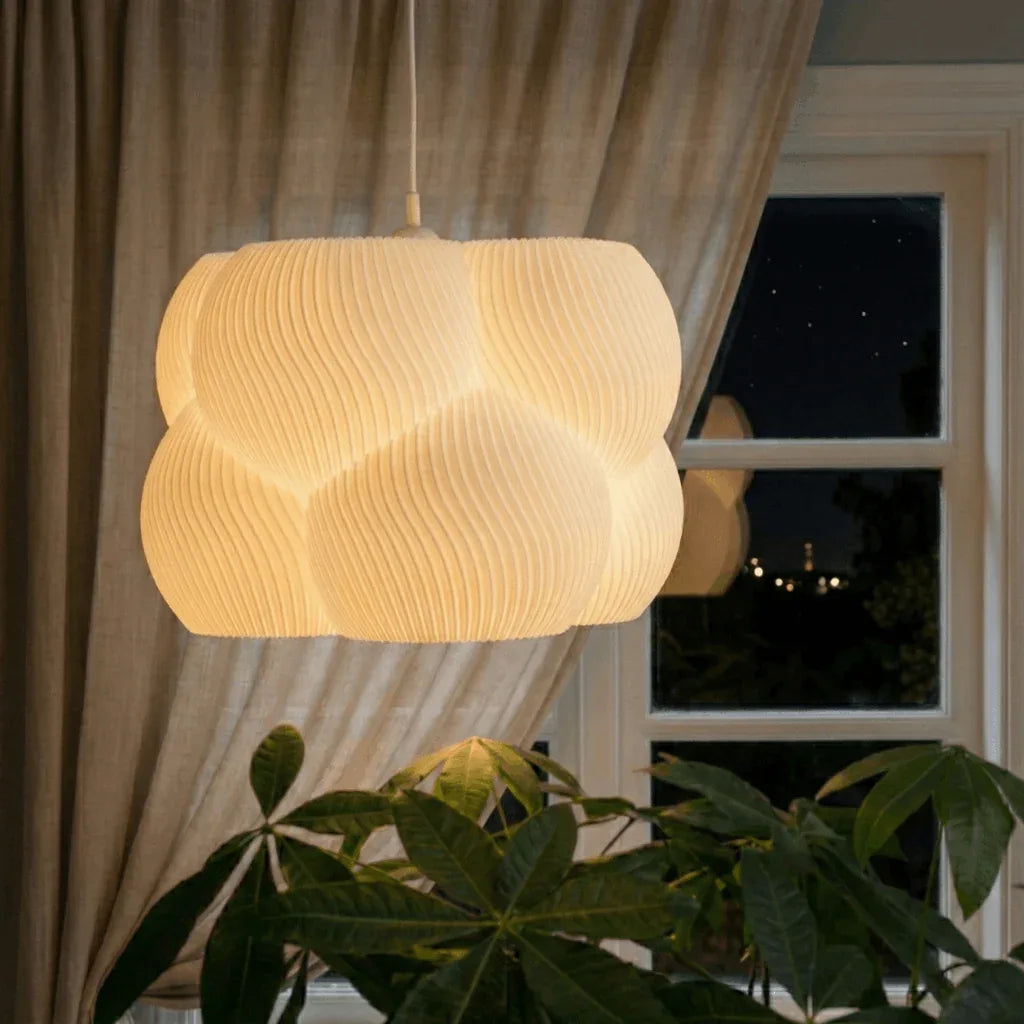 Lampe bubble imprimée 3D allumée devant une fenêtre.