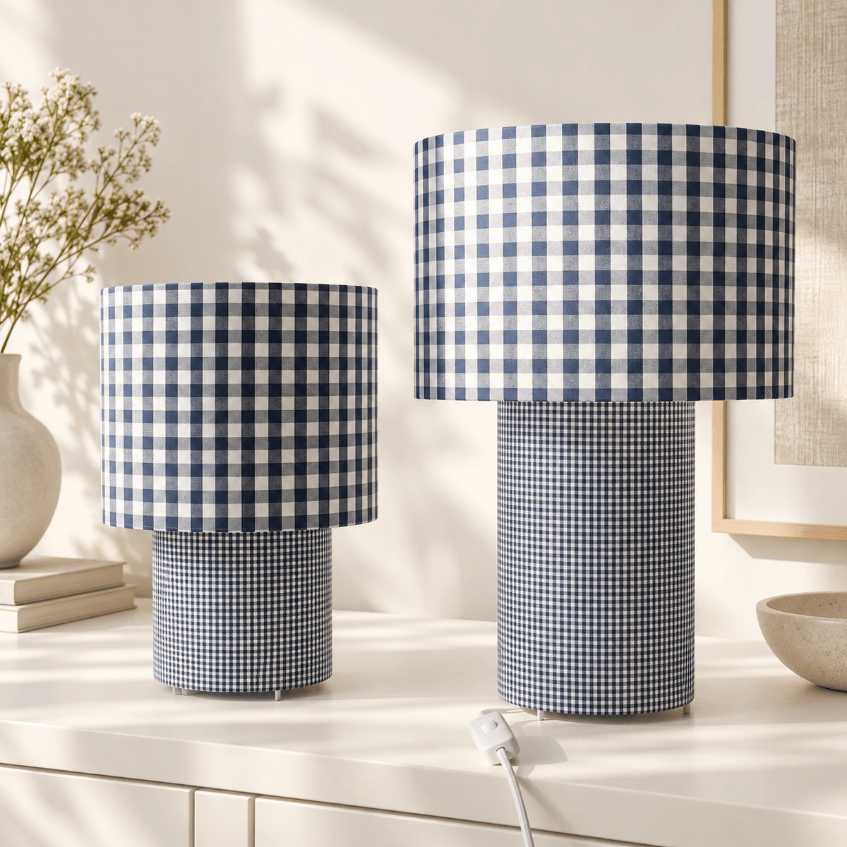 Deux lampes à poser assorties en tissu vichy bleu et blanc, proposées en deux formats, avec abat-jour à grands carreaux et pied cylindrique à motif plus fin.