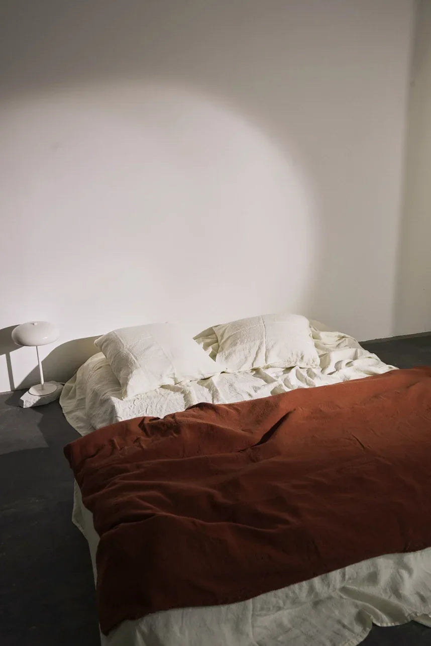 Edredons en lin de différentes couleurs sur un lit