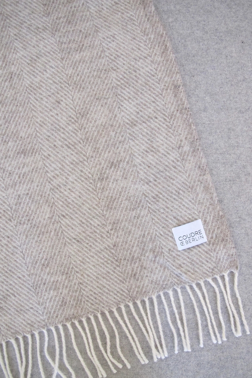 Plaid beige sur un canapé.