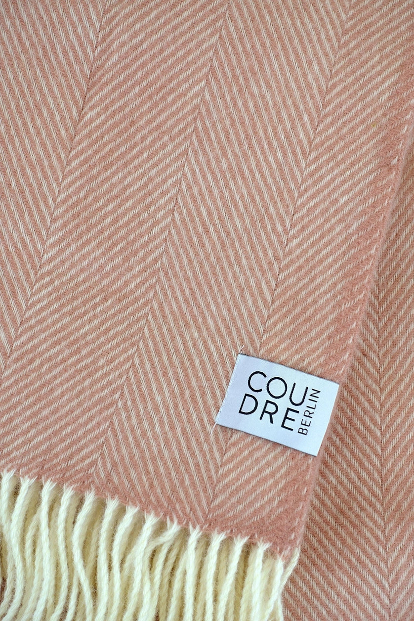 Plaid rose sur un canapé.