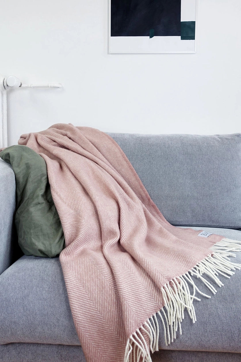 Plaid rose sur un canapé.