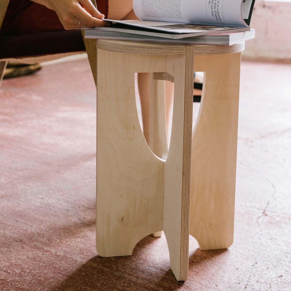 Tabouret en bois avec quelques magazines dessus.