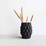 Vase noir sur fond blanc.