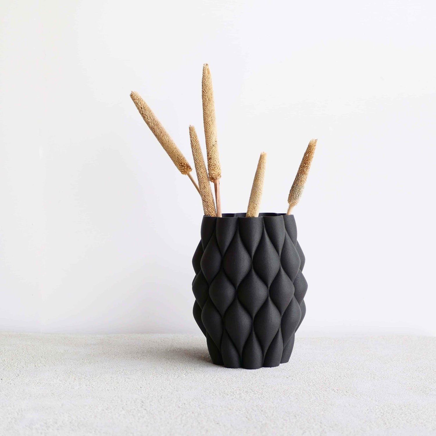 Vase noir sur fond blanc.