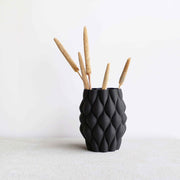 Vase noir sur fond blanc.