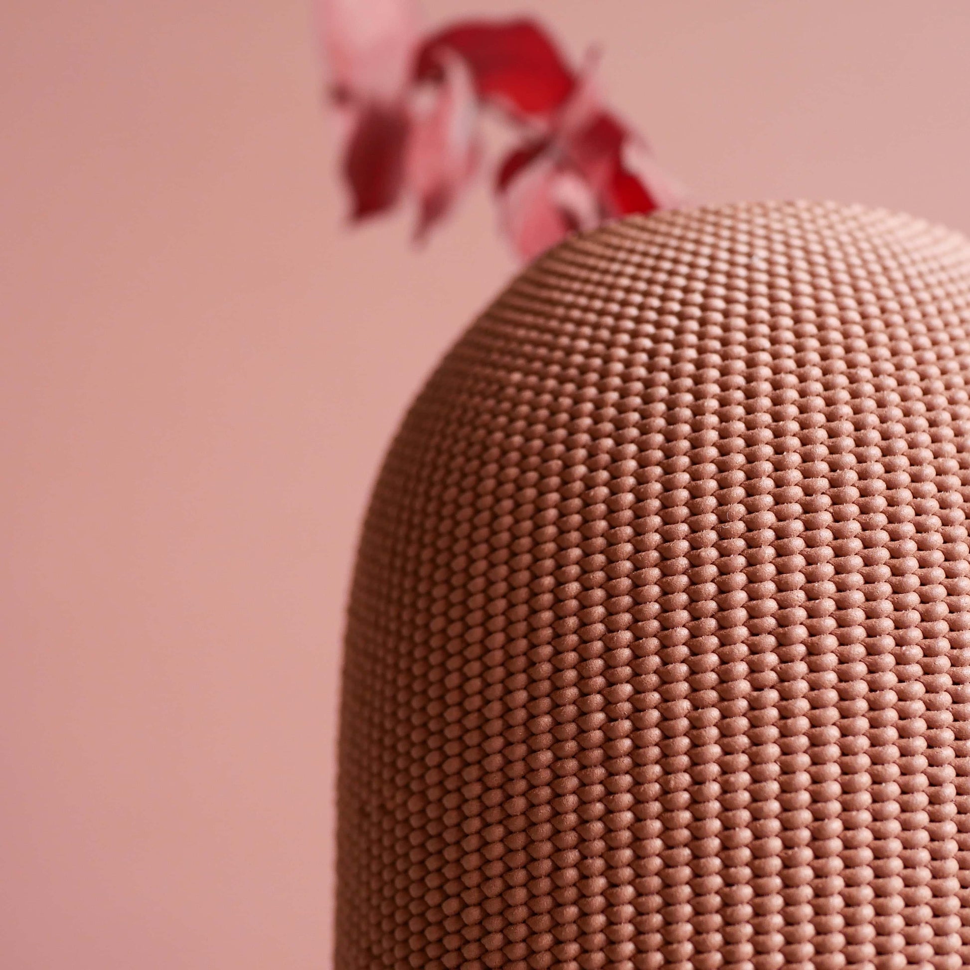 Zoom sur la matière d'un vase rose sur fond rose.