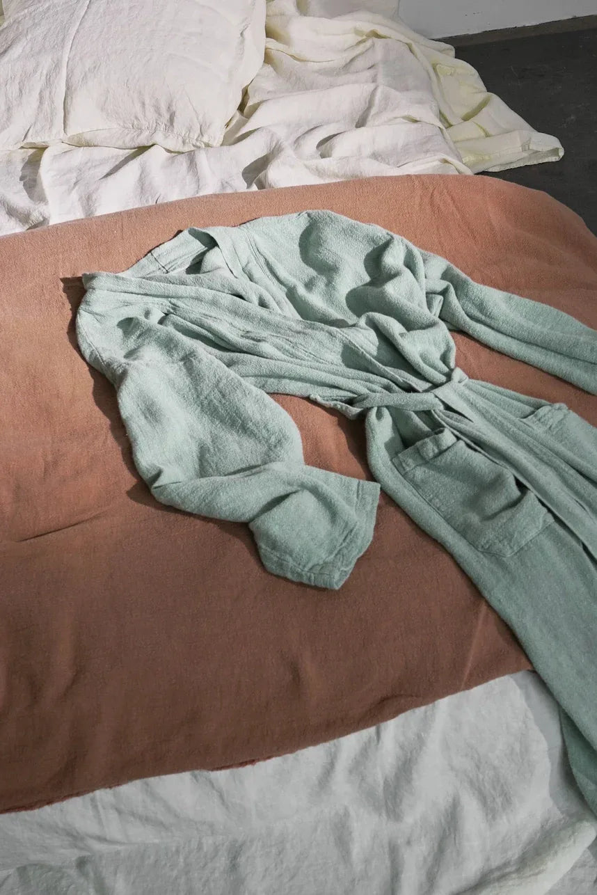 Kimono bleu vert posé sur un lit