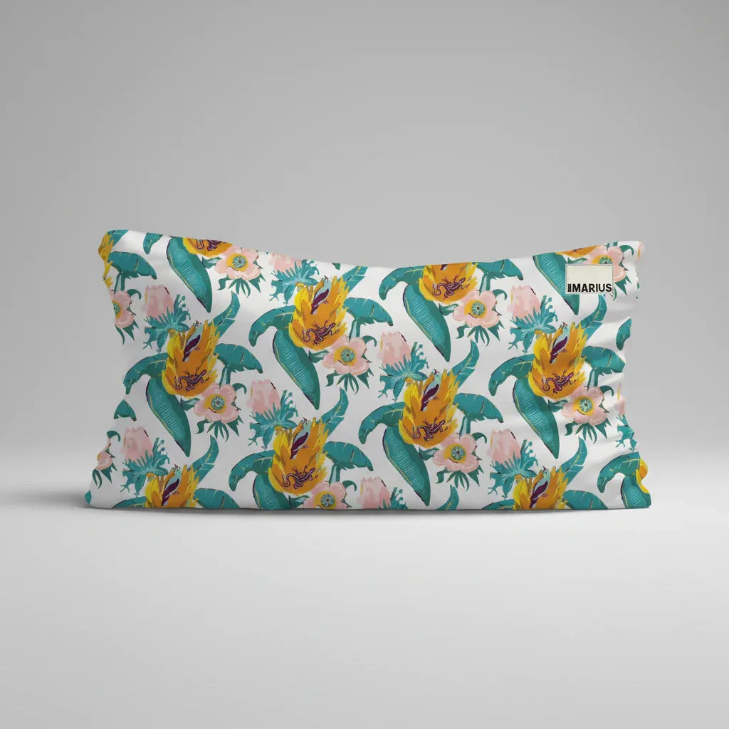 Un coussin rectangulaire avec un motif floral vibrant composé de fleurs jaunes, roses et sarcelles et de feuilles vertes sur un fond blanc. Une petite étiquette Où est MARIUS est visible dans le coin supérieur droit.