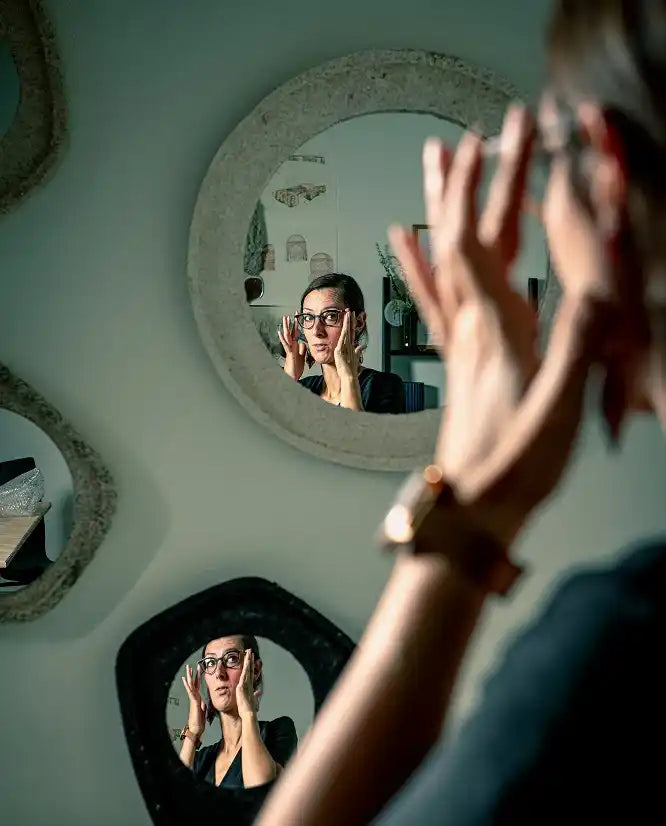 Portrait d’une designer se regardant dans un miroir dans son atelier, scène de travail et de création.