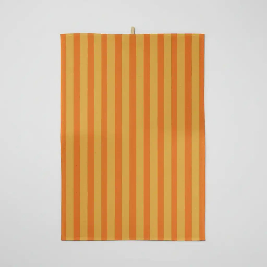 Un torchon rectangulaire avec des rayures verticales orange et jaunes alternées, sur un fond blanc uni. Une petite boucle de suspension est attachée en haut au centre.